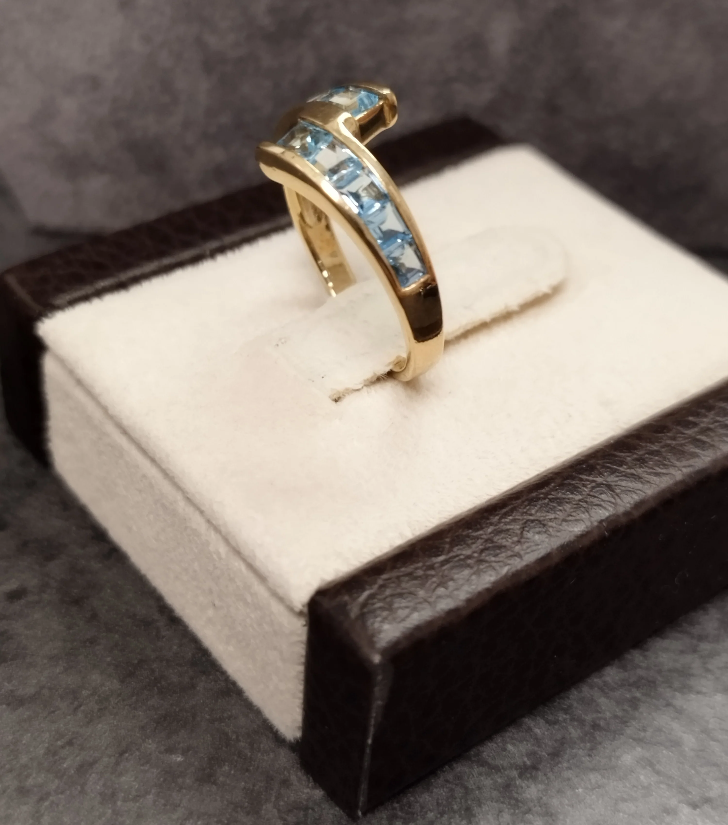 9ct Yellow Gold Crossover Ring Channel set with Light Blue Stones - Size M - Image 2